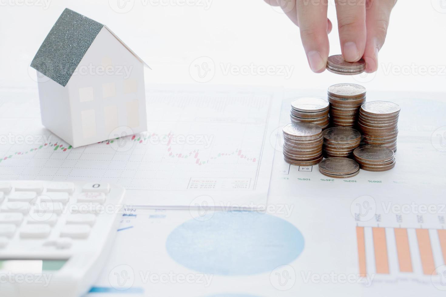 investimento imobiliário. casa e moedas na mesa. foto