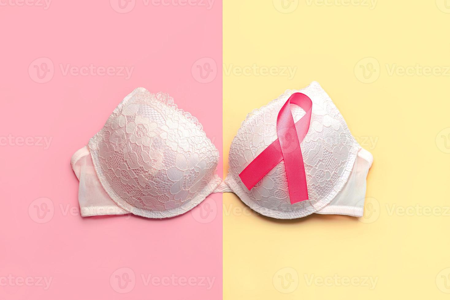 conceito de câncer de mama. vista superior do sutiã feminino e da fita rosa símbolo conscientização do câncer de mama foto