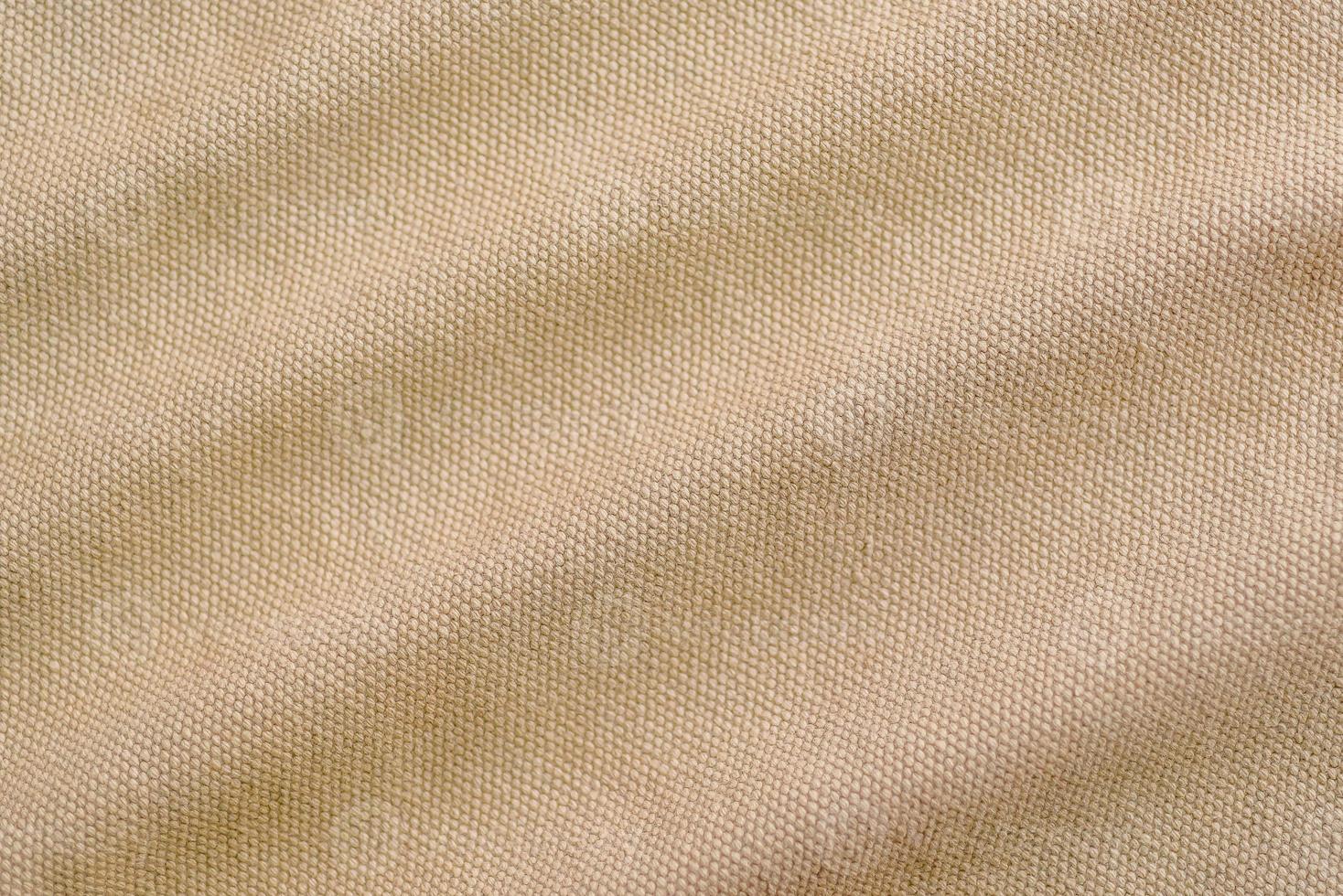 textura de close-up e ondulado de tecido de lona marrom claro como plano de fundo foto