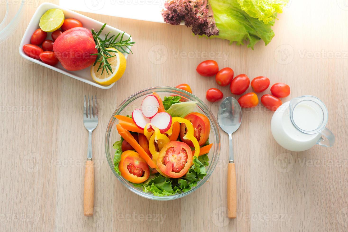 vista superior da tigela de salada de legumes frescos, legumes mistos, como rabanetes, tomates, cenouras, carvalho verde, carvalho vermelho e tomates, maçãs e leite integral são preparados em torno dele. foto