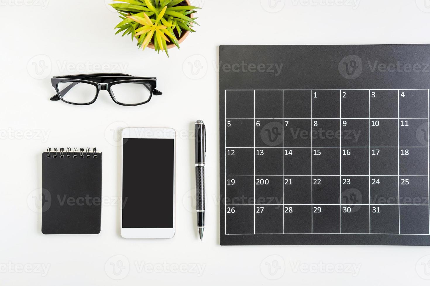 calendário de planejamento com smartphone no escritório de mesa de negócios, vista superior foto