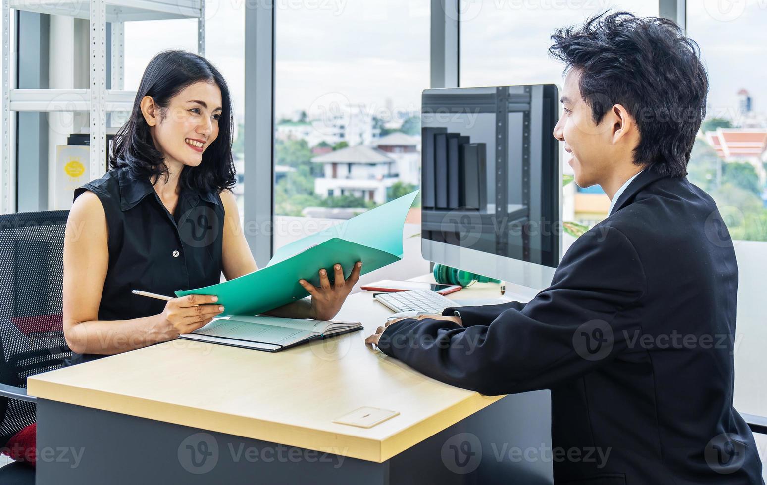 entrevista de emprego, bela gerente asiática conversando com um candidato a emprego masculino na mesa, empresária ouve as respostas dos candidatos. foto