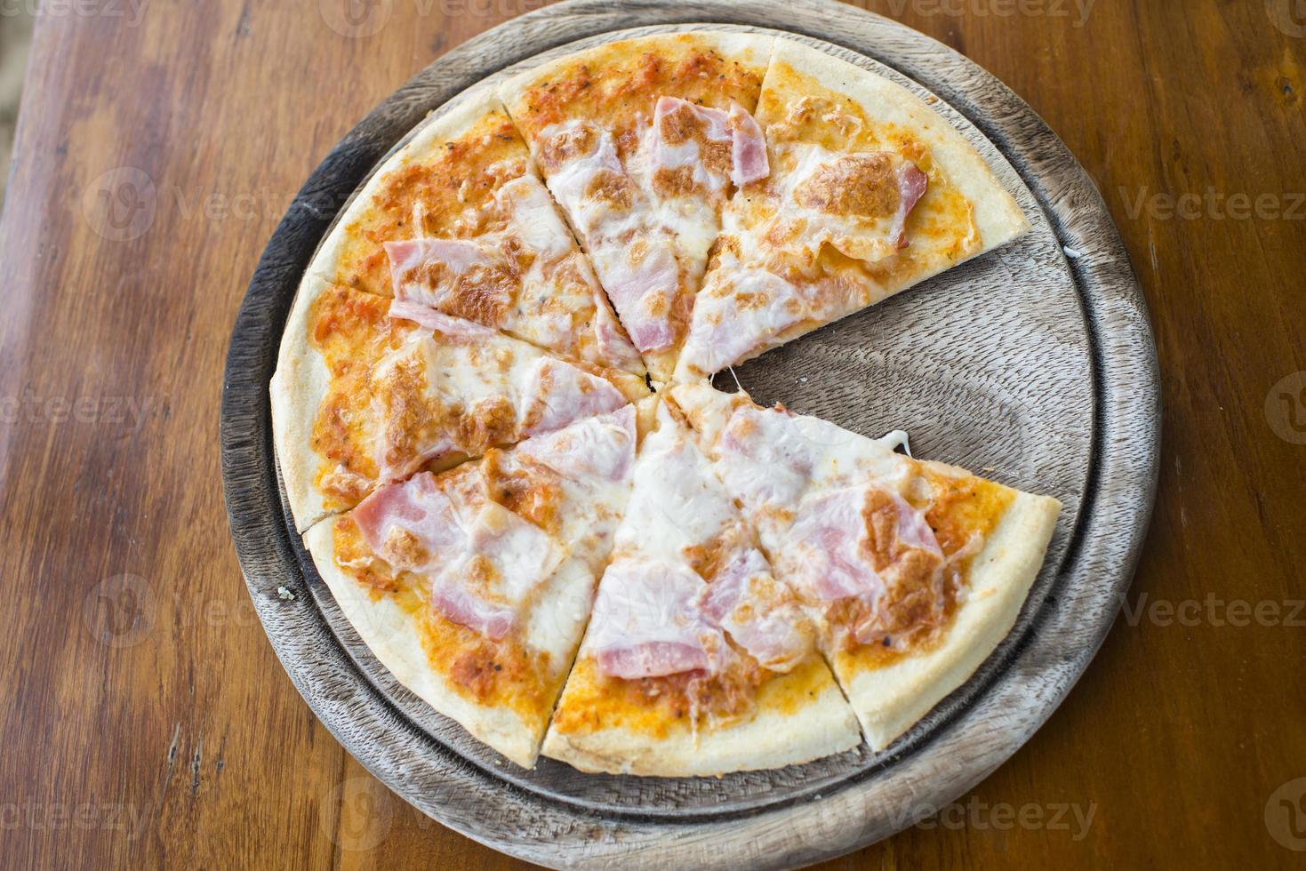 presunto de pizza caseira na mesa de madeira. foto
