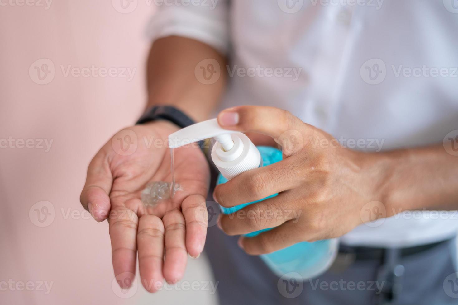 as mãos dos homens usam gel para lavar as mãos, gel para lavar as mãos, bomba dispensadora para limpar e se livrar do vírus pandêmico. foto