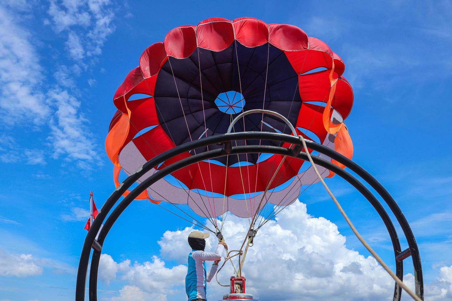 homem asiático preparando parapente. bali indonésia, dezembro de 2021 foto