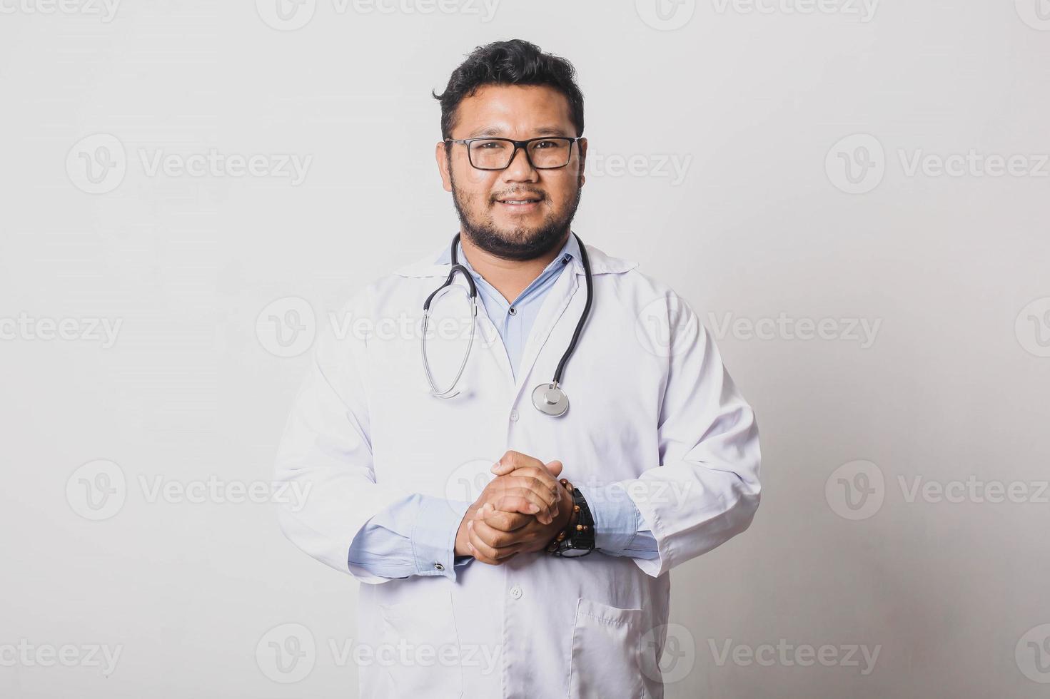 médico masculino casual posando com as palmas das mãos juntas isoladas no fundo branco foto