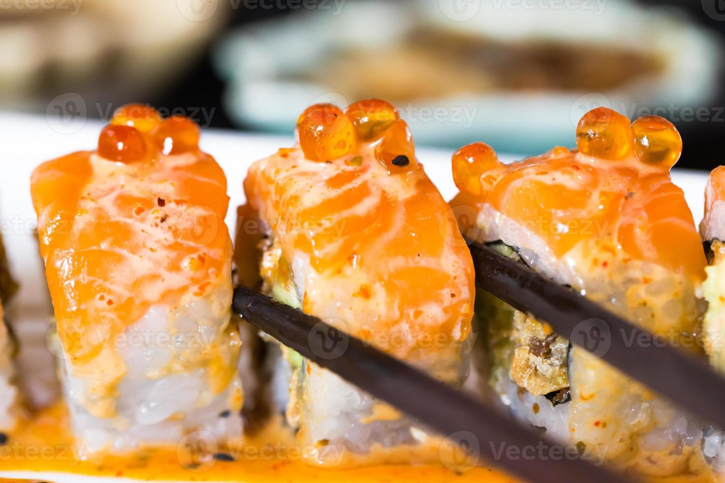 rolo de sushi com pauzinhos pretos foto