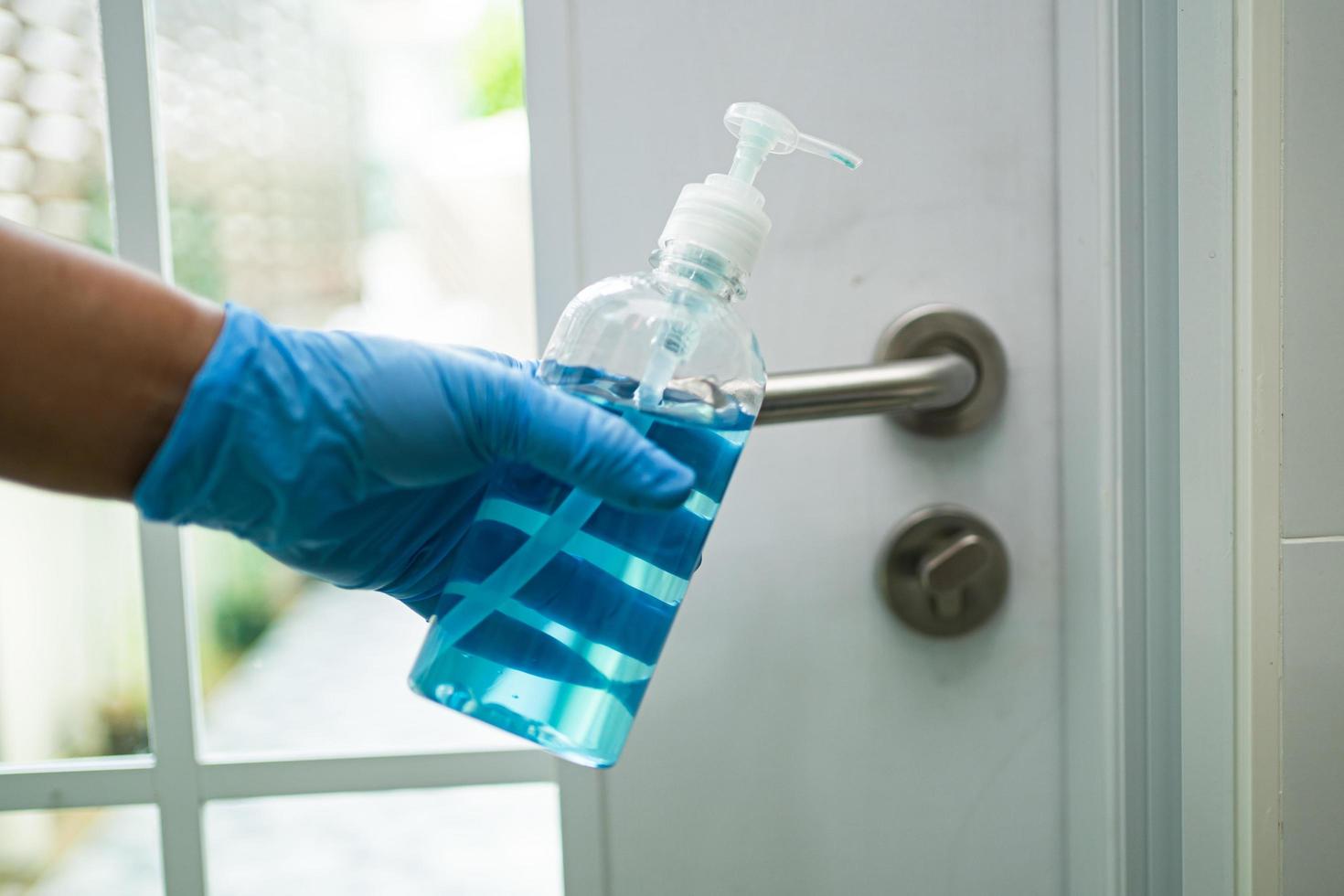 limpeza da maçaneta da porta com álcool no escritório e em casa para proteger o coronavírus covid 19. foto