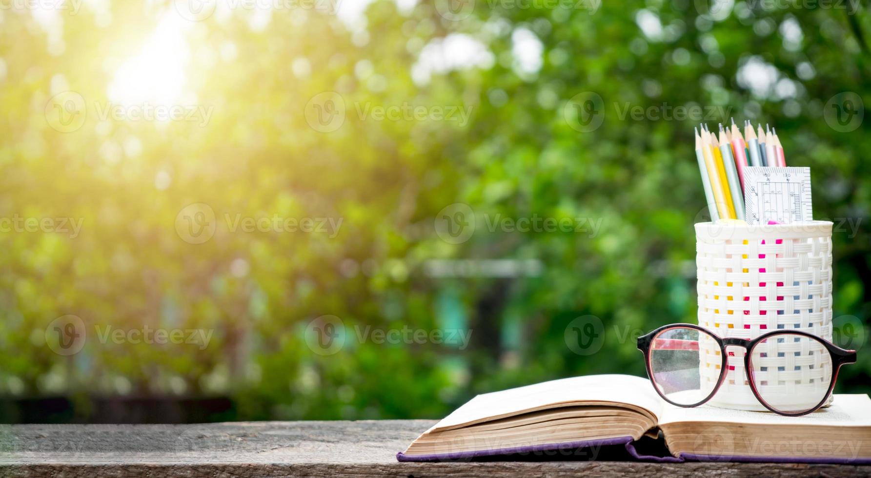 de volta ao fundo da escola com livros, lápis e régua em fundos desfocados verdes com espaço de cópia. foto