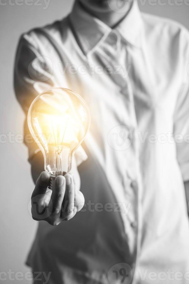 a imagem em preto e branco de uma mulher com uma lâmpada, ideias inovadoras, inspiração e criatividade. foto