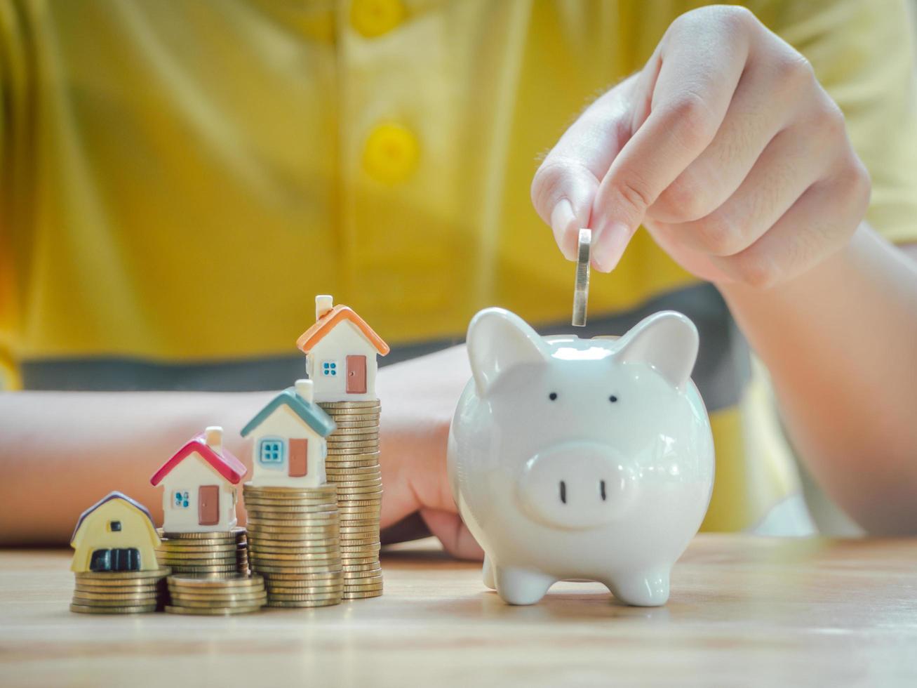 menino asiático segurando moedas soltar um recipiente economizando dinheiro para economizar dinheiro investir para o futuro e comprar empréstimo home.concept, escada de propriedade, financeiro, investimento imobiliário e bônus. foto