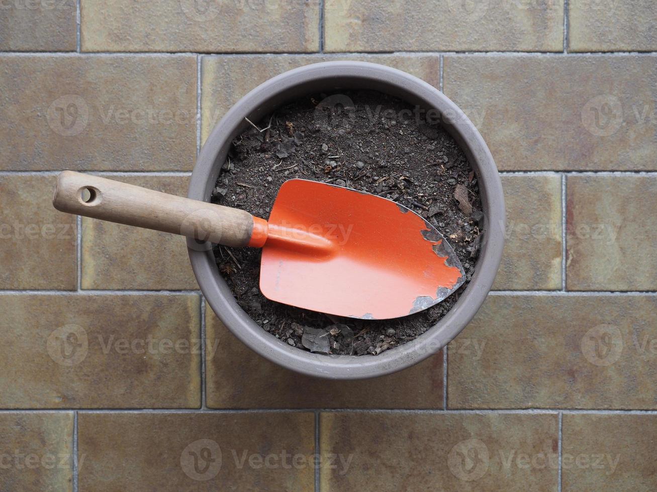 pá de jardim e balde de terra para vasos de plantas foto