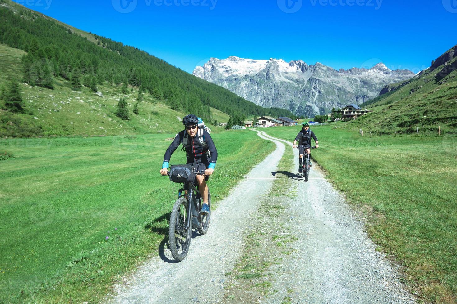 casal de amigos ciclistas durante um passeio na estrada de montanha foto