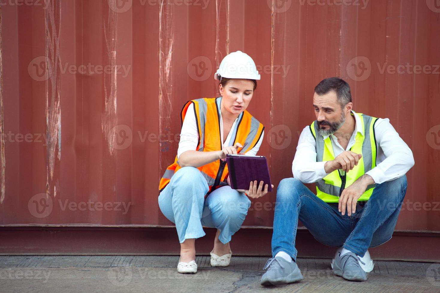gerente masculino e feminino sentam e discutem sobre seu trabalho para envio ao cliente. distribuição armazenamento comércio porto de carga. foto
