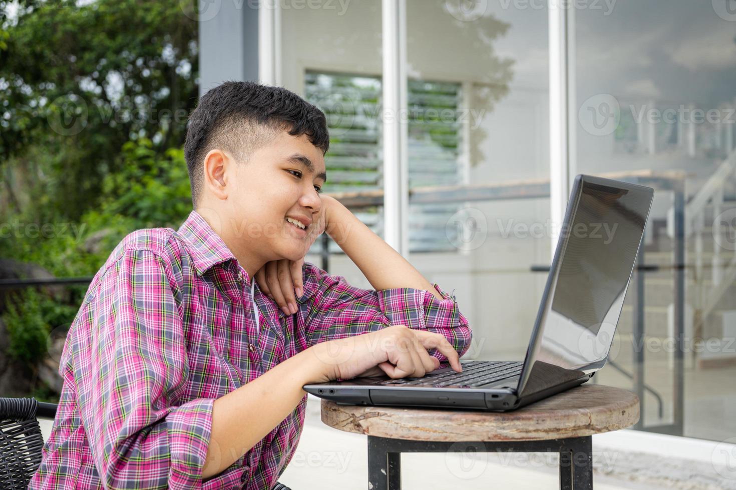 meninos asiáticos gostam de estudar online na frente de suas casas durante as férias escolares. foto