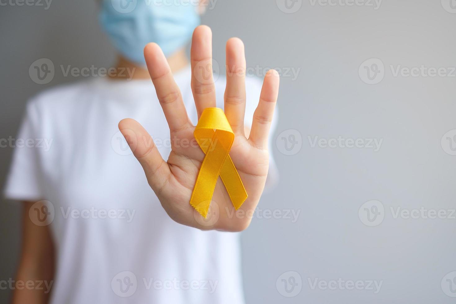 dia de prevenção do suicídio, sarcoma, osso, bexiga e mês de conscientização do câncer infantil, fita amarela para apoiar as pessoas que vivem e estão doentes. saúde infantil e conceito de dia mundial do câncer foto