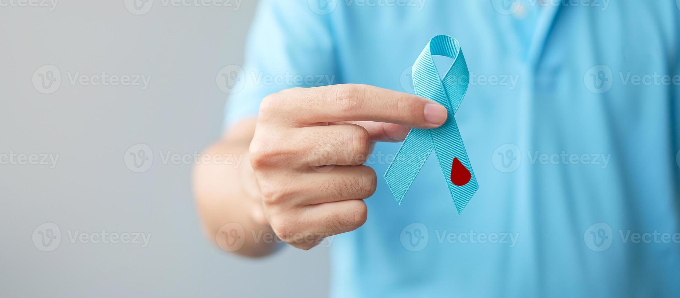 novembro mês de conscientização do dia mundial do diabetes, homem segurando fita azul clara com forma de gota de sangue para apoiar as pessoas que vivem, prevenção e doença. cuidados de saúde, conceito de dia do câncer de próstata foto