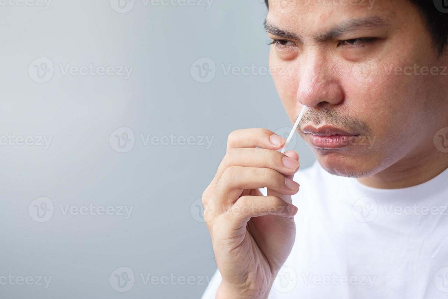 homem cotonete teste covid-19 pelo kit de teste rápido de antígeno. teste nasal ou doméstico de coronavírus, conceito de bloqueio e isolamento doméstico foto