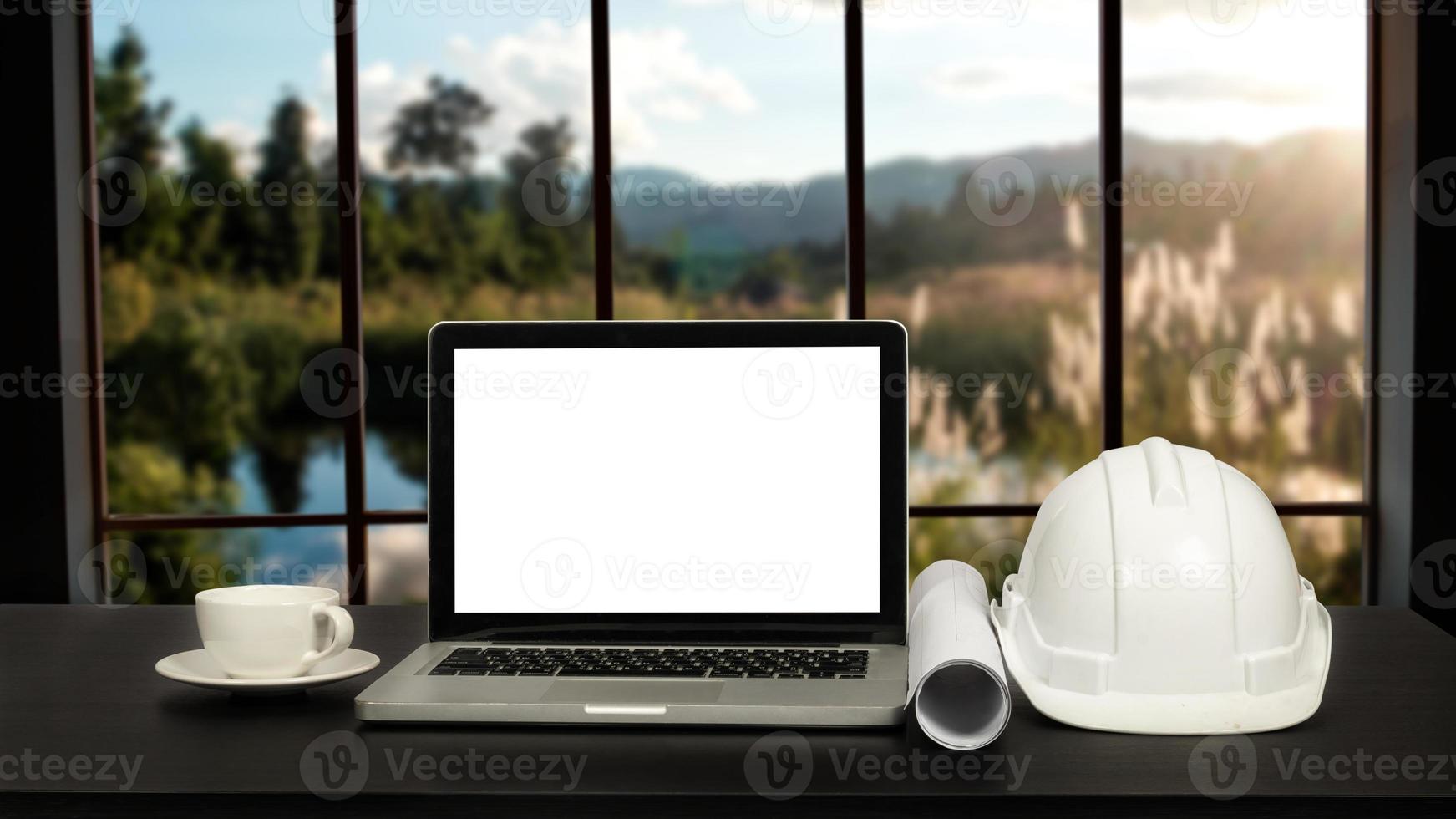 espaço de trabalho do advogado com tela branca em branco do laptop e martelo de madeira de lei e escala de bronze do juiz. foto