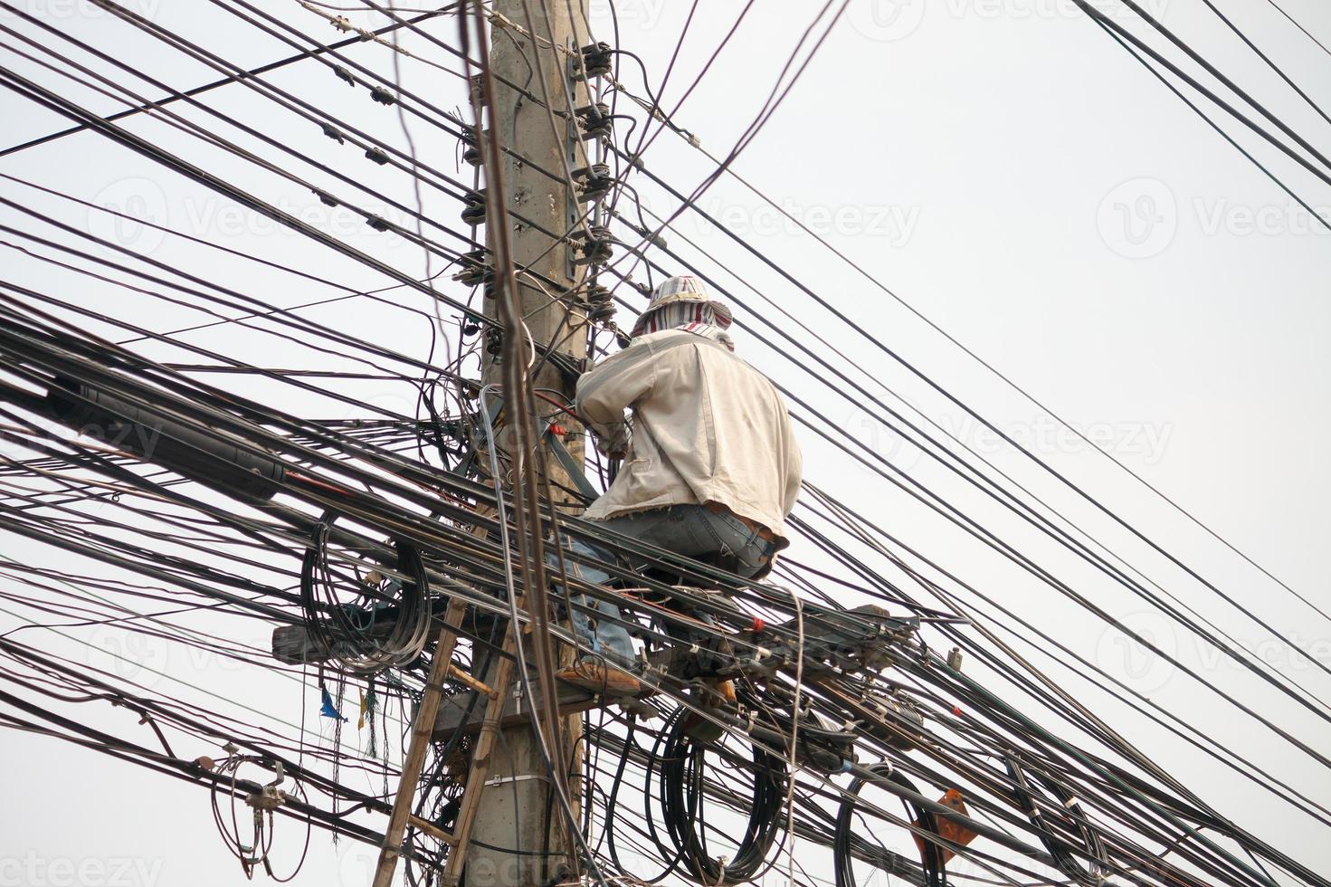eletricista em postes elétricos foto