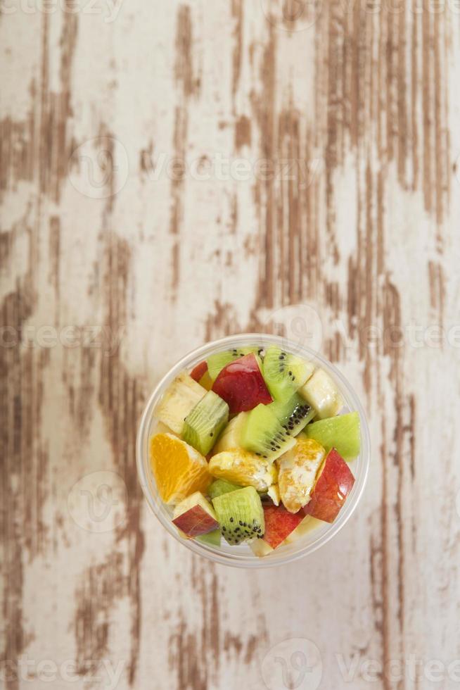 Vista aérea de salada de frutas na placa de madeira foto