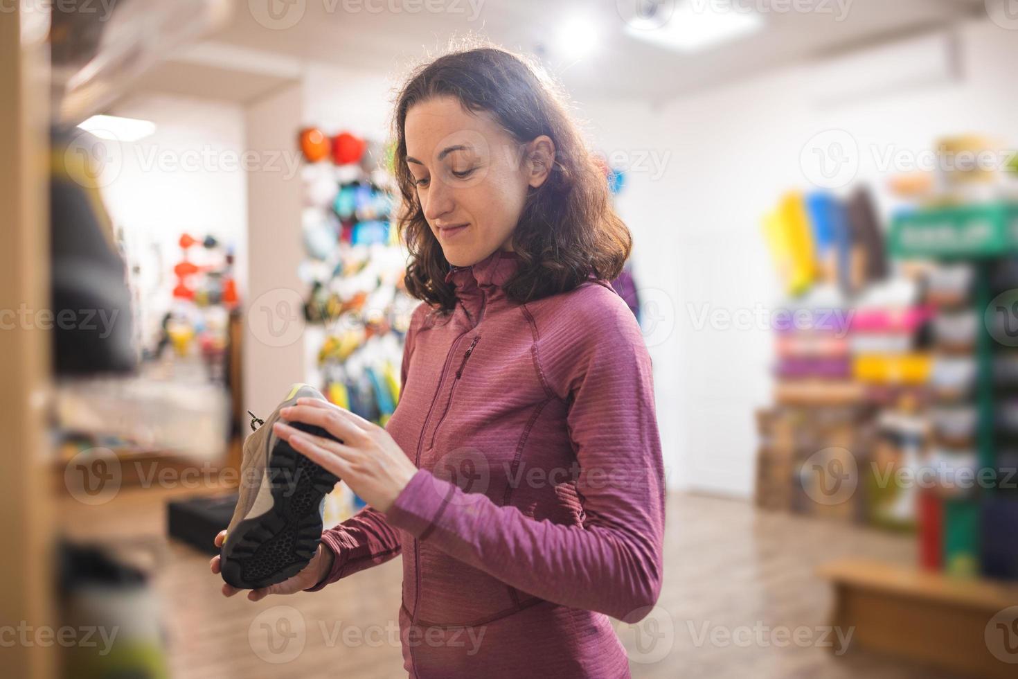 menina escolhe sapatos na loja foto