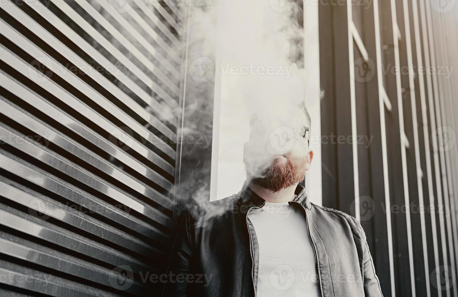 homem fuma um cigarro eletrônico foto