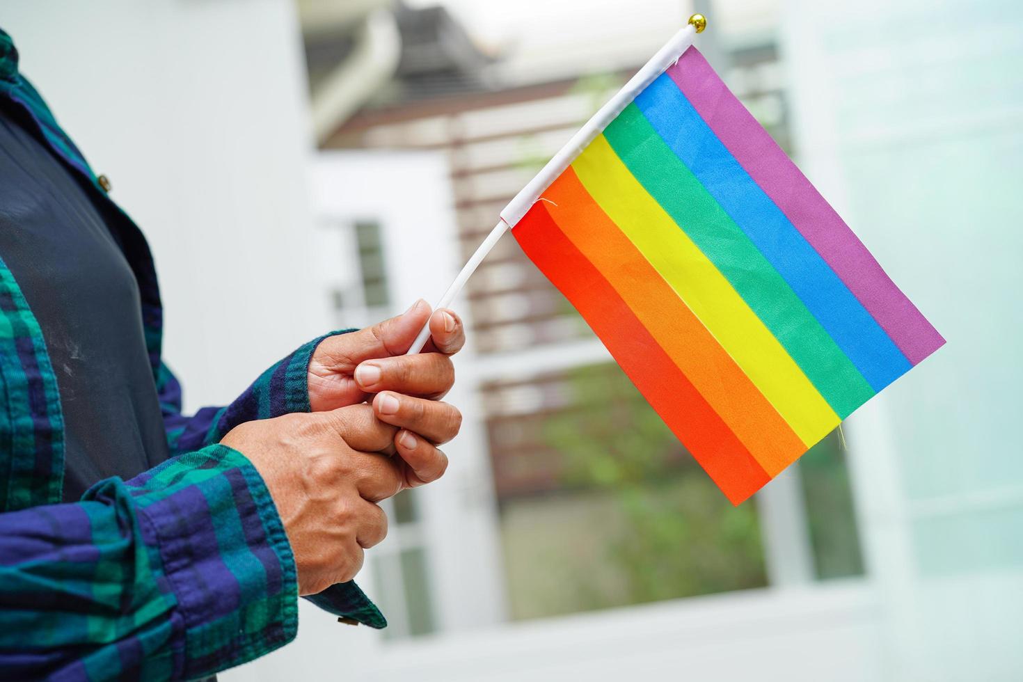 mulher asiática com bandeira do arco-íris, direitos do símbolo lgbt e igualdade de gênero, mês do orgulho lgbt em junho. foto