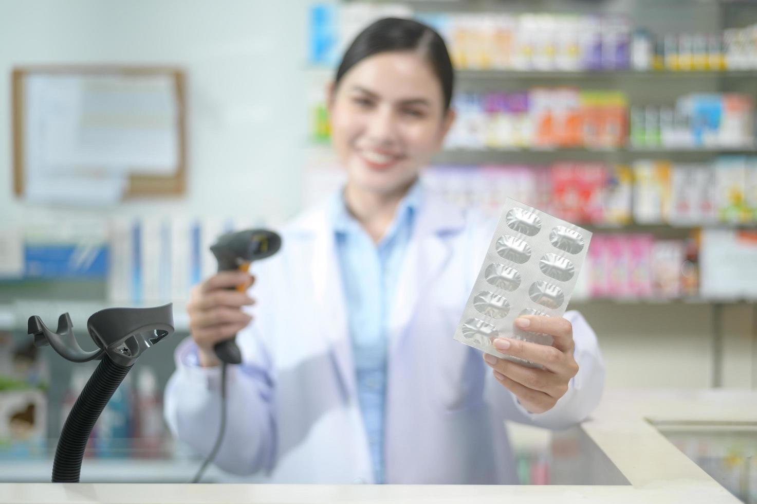 farmacêutico feminino escaneando código de barras em uma caixa de remédios em uma farmácia moderna. foto