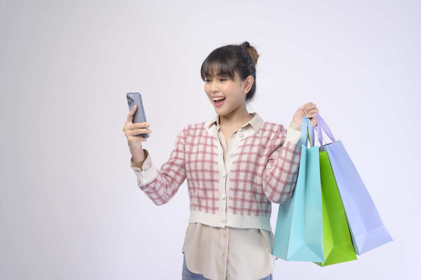 mulher atraente cliente segurando sacolas de compras sobre fundo branco foto