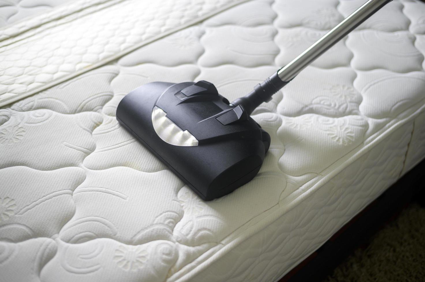 limpeza doméstica está usando máquina removedora de ácaros na cama. foto