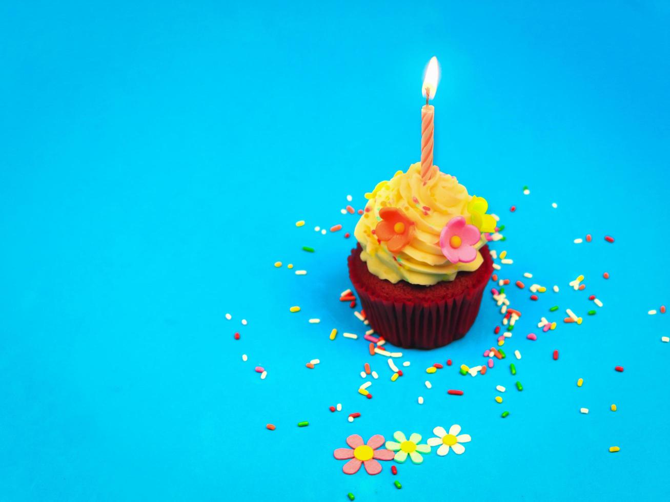 feliz aniversário cupcake e vela de arco em fundo azul com espaço de cópia, bolo fofo na festa de aniversário. foto
