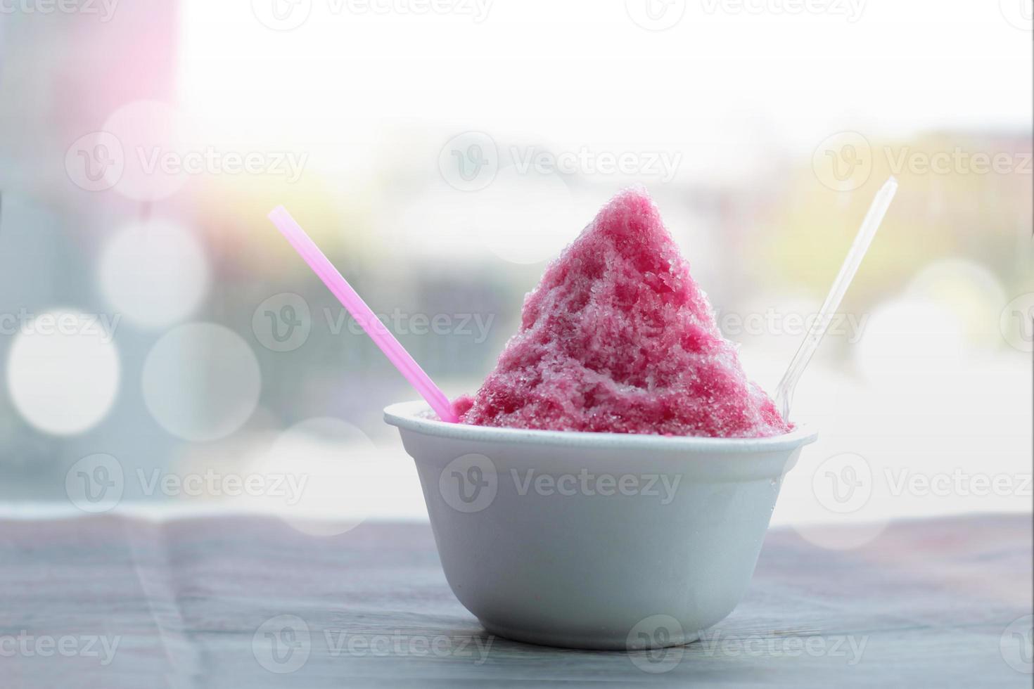doce sobremesa de gelo raspado caseiro em copo de espuma na mesa de madeira, conceito de sobremesa fofa de verão foto