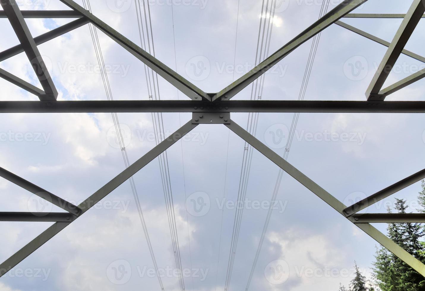 vista de perto em um grande poste de energia transportando eletricidade em uma área rural foto