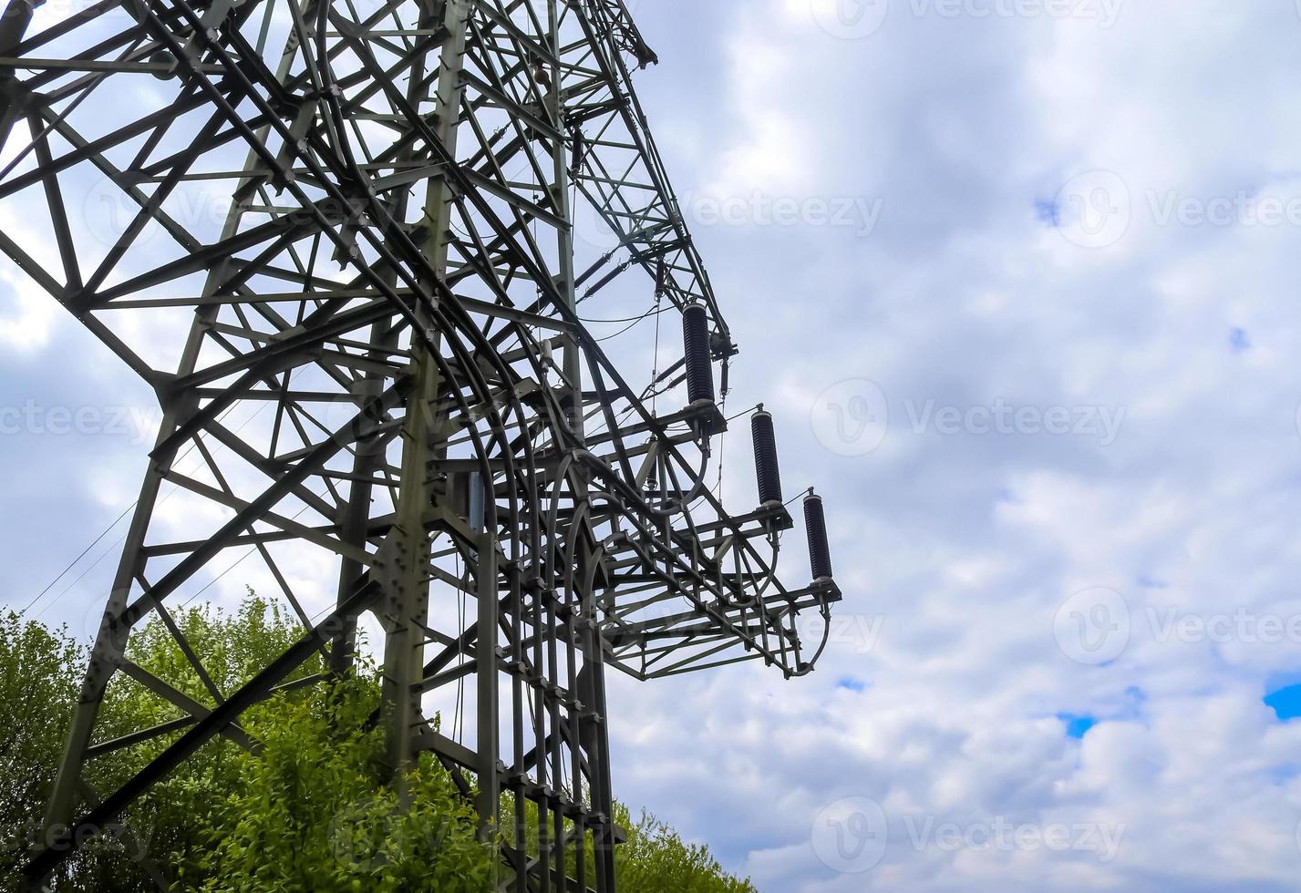 vista de perto em um grande poste de energia transportando eletricidade em uma área rural foto