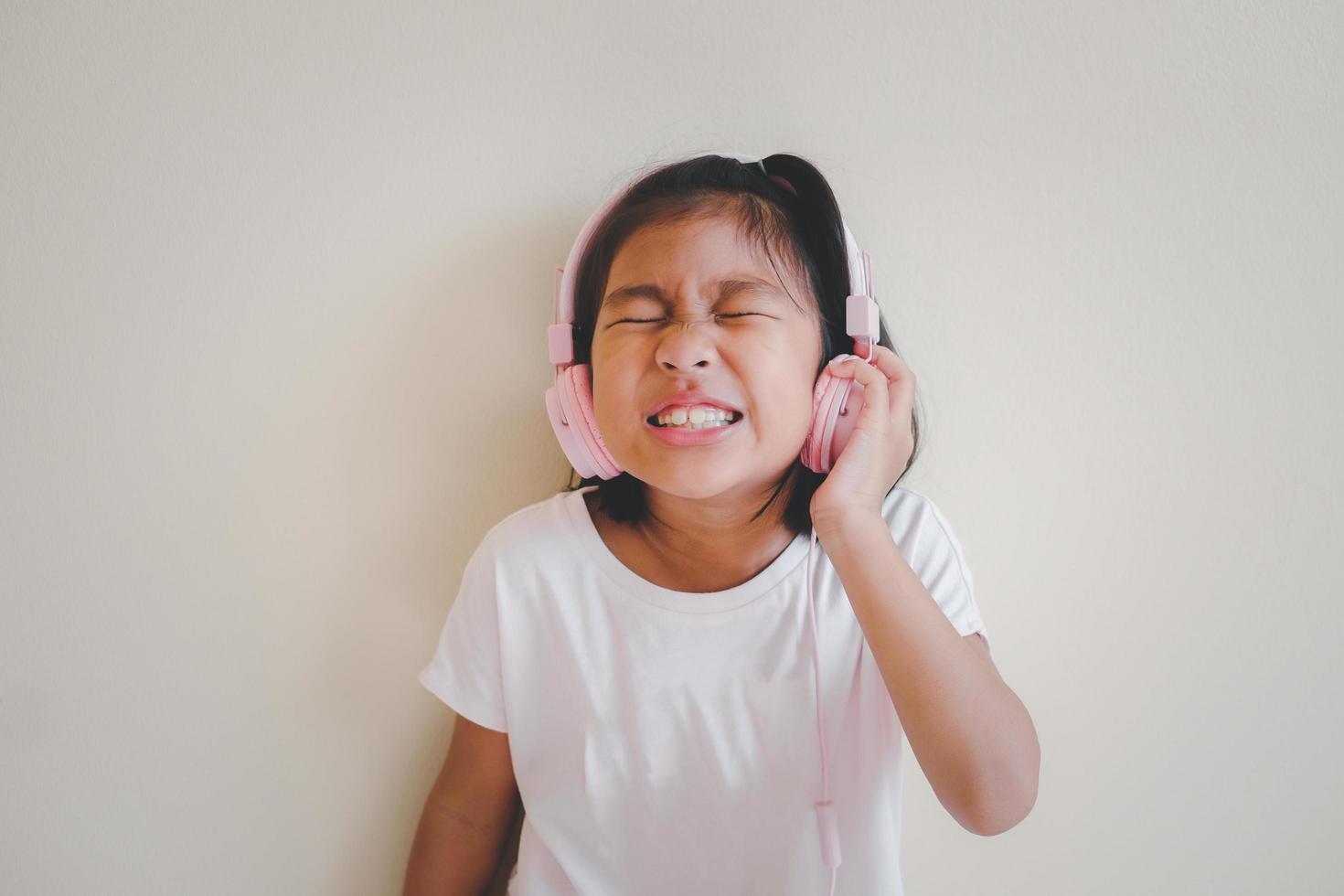 retrato de jovem asiática feliz curtindo música com fones de ouvido em fundo branco. aproveite o conceito de som. foto