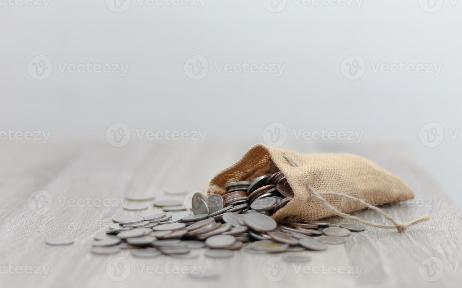 moedas no saco na mesa de madeira foto