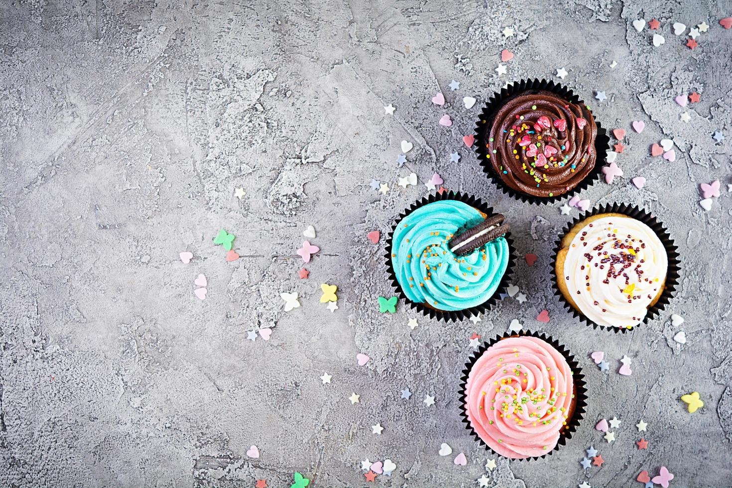 saborosos cupcakes coloridos isolados em fundo cinza. bolinho delicioso foto