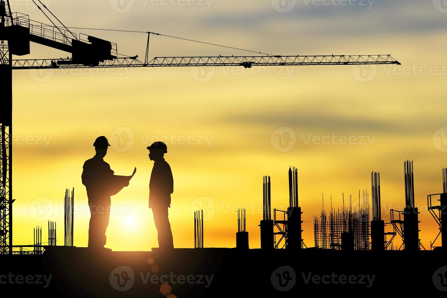 silhueta de arquiteto trabalhando em trabalhadores do canteiro de obras na hora do pôr do sol. foto