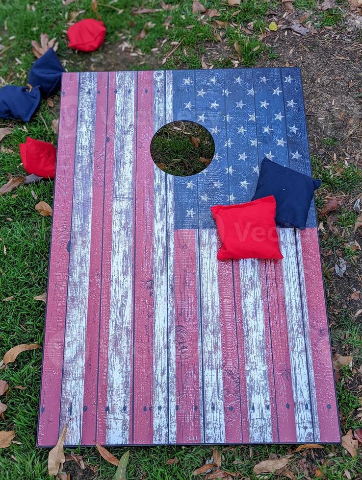 jogo de cornhole vermelho branco e azul com estrelas para parecer uma bandeira americana com sacos de feijão foto