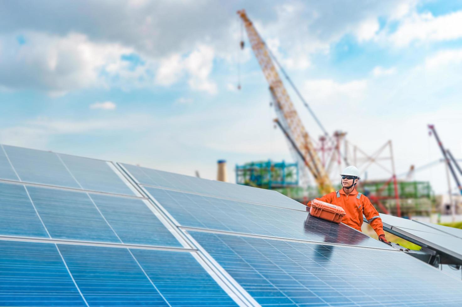 engenheiros possuem uma ferramenta para verificar o desempenho do painel solar para confirmar os sistemas funcionando normalmente. ideia de módulo fotovoltaico para produção de energia limpa, a construção é o pano de fundo foto