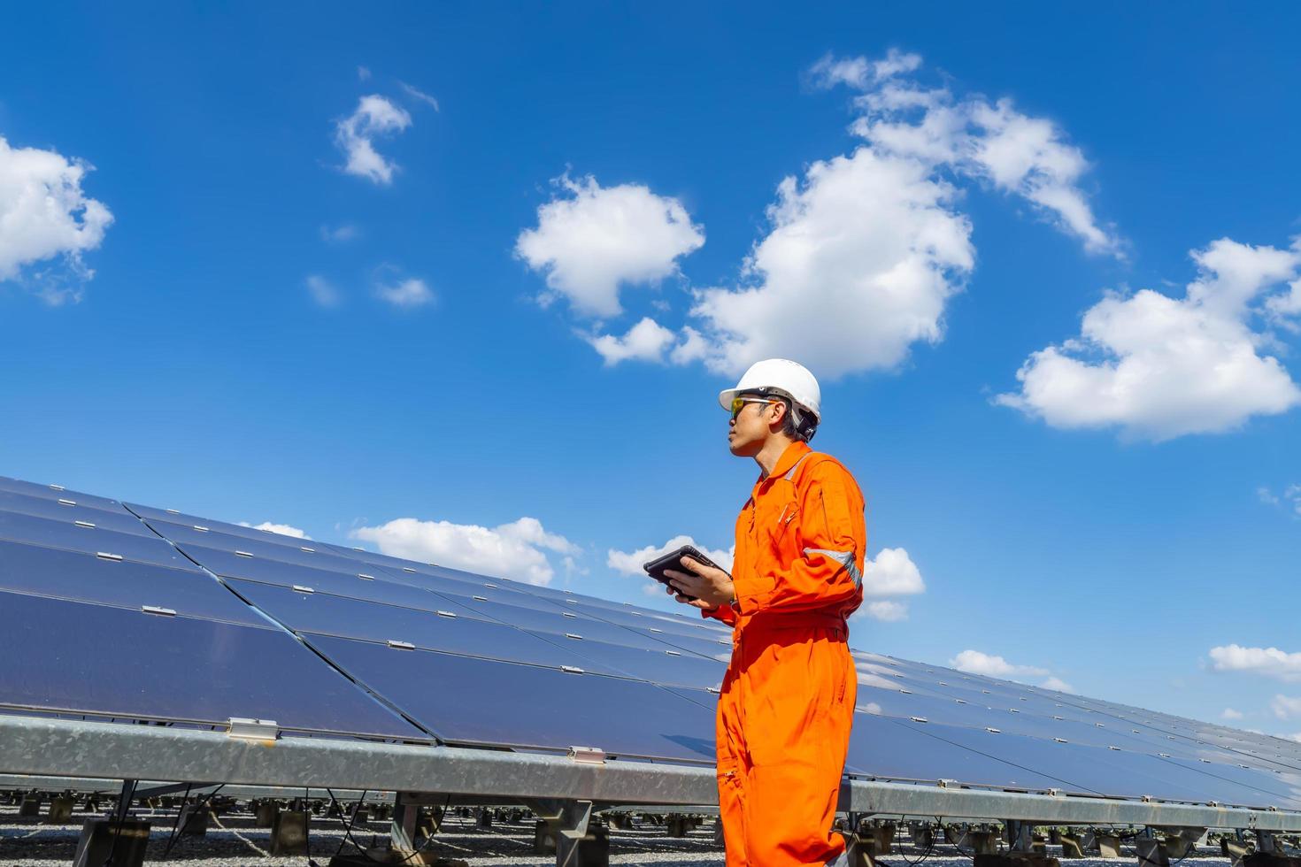 a fazenda solar, painel solar com engenheiros caminham para verificar o funcionamento do sistema, energia alternativa para conservar a energia do mundo, ideia de módulo fotovoltaico para produção de energia limpa foto