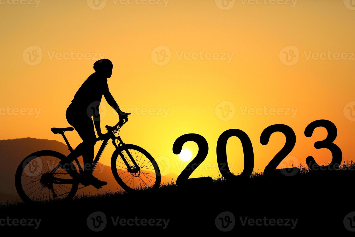 silhueta de ciclista de montanha e feliz ano novo 2023 foto