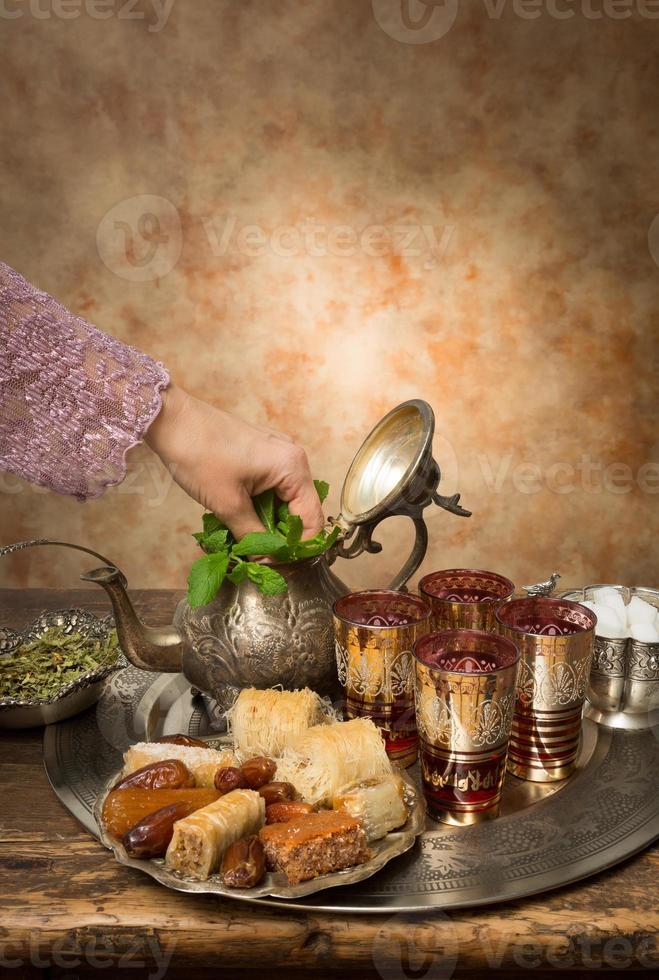 adicionando hortelã ao chá marroquino foto