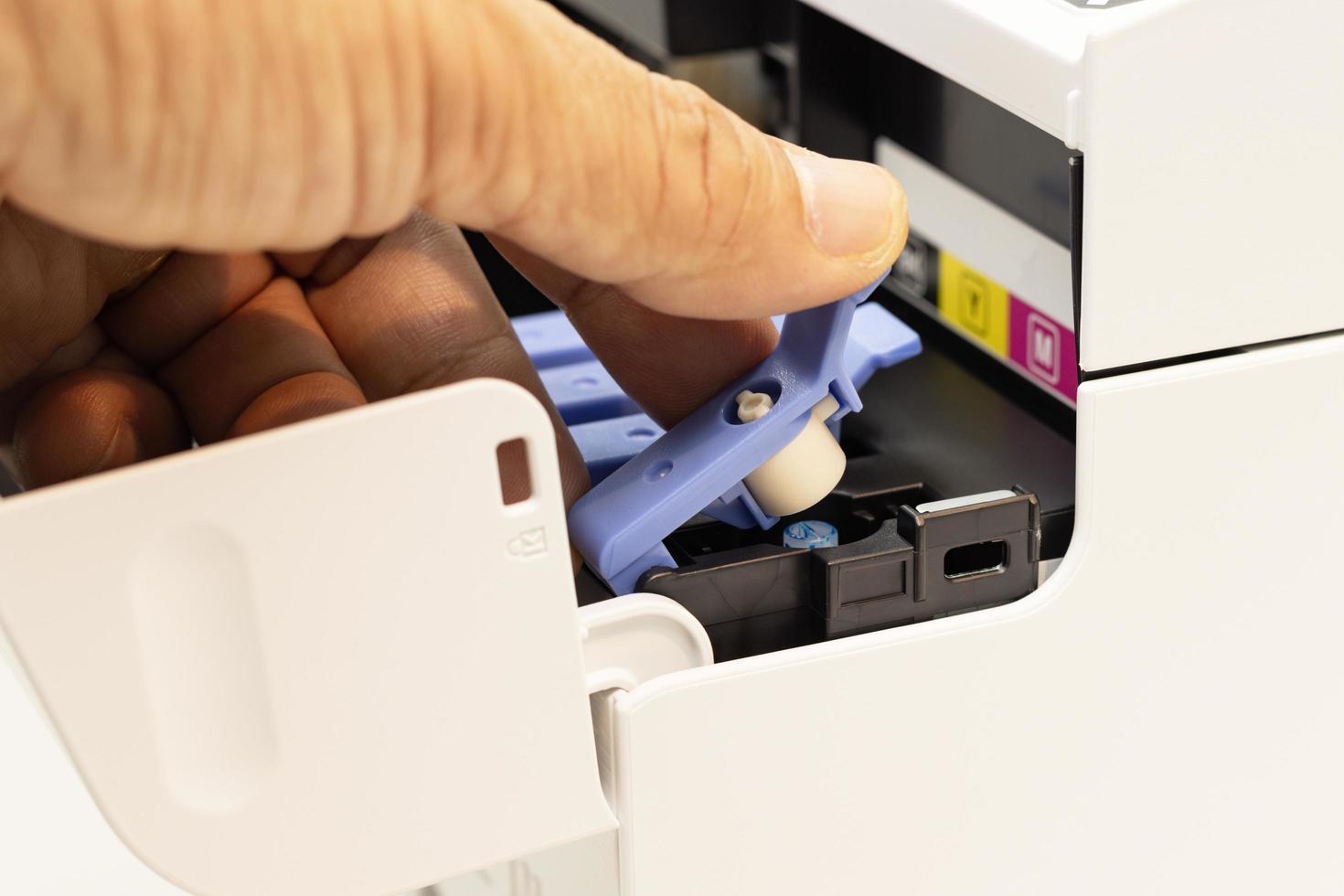 os técnicos cobrem o orifício de preenchimento com um selo de uma impressora a jato de tinta, o dispositivo de escritório automatizado para impressão foto