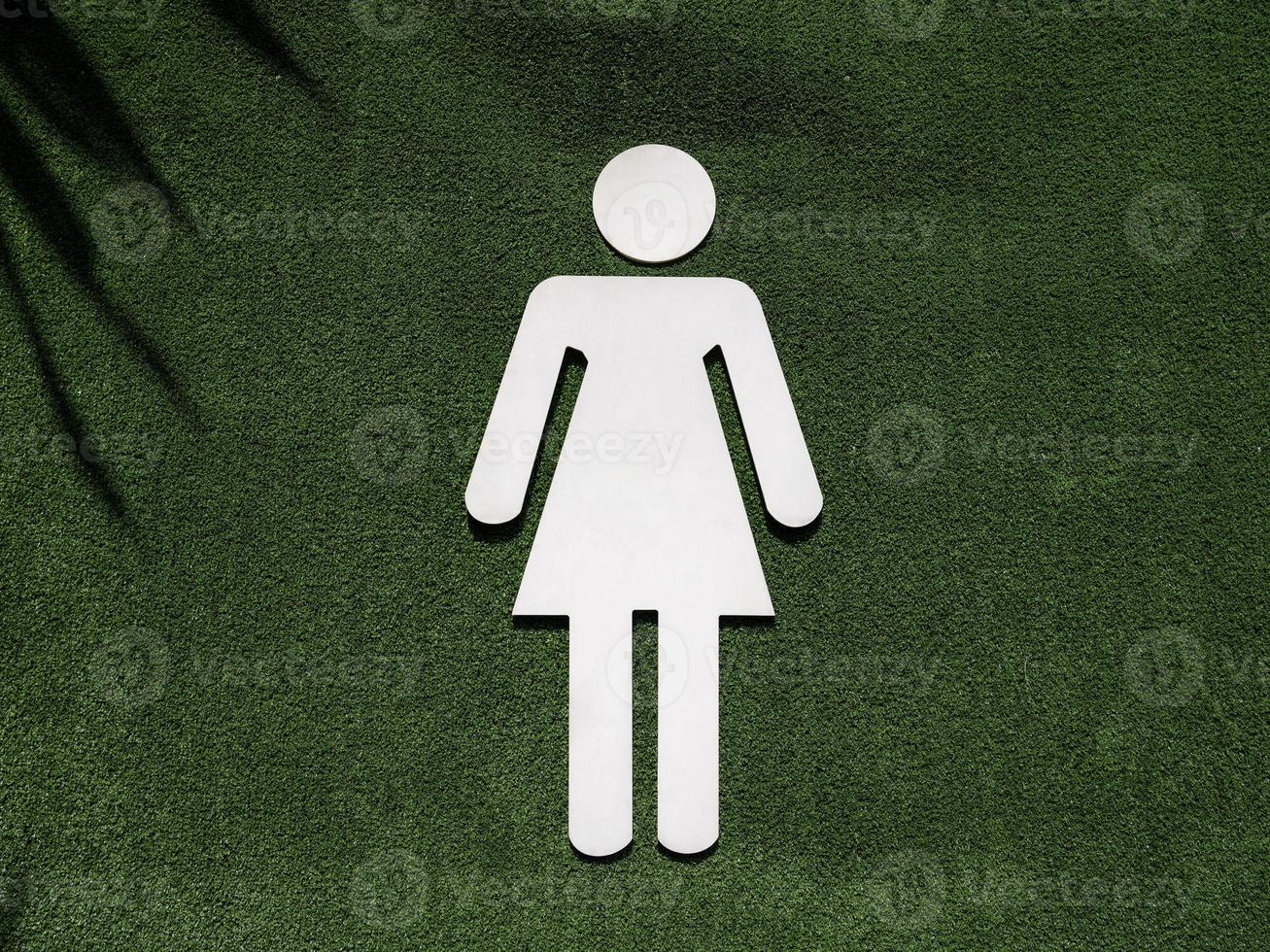 símbolo de banheiro feminino na grama verde falsa foto