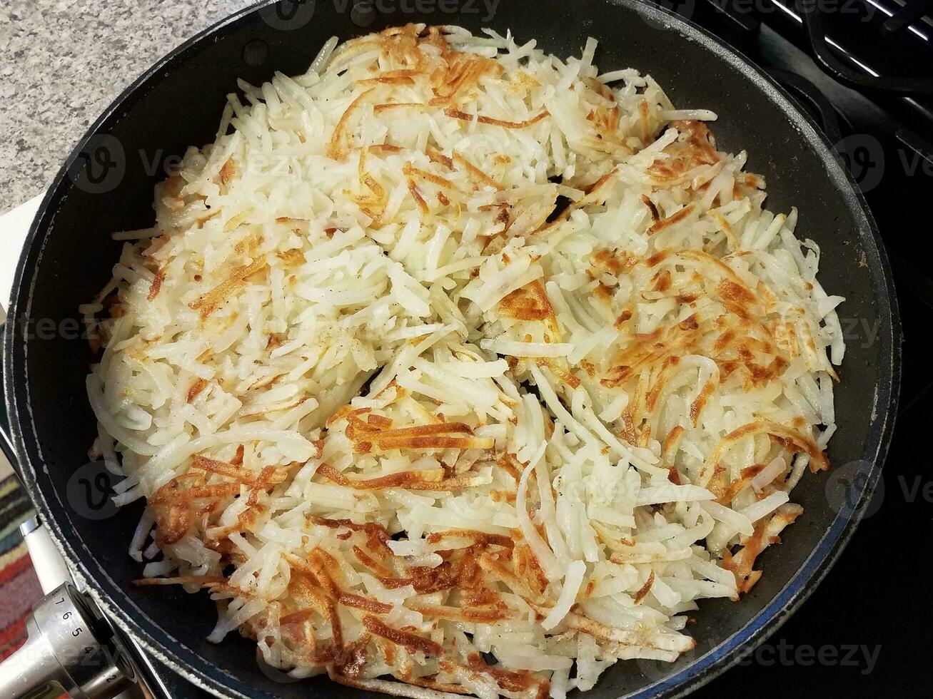 hash brown batatas cozinhando na frigideira ou frigideira foto