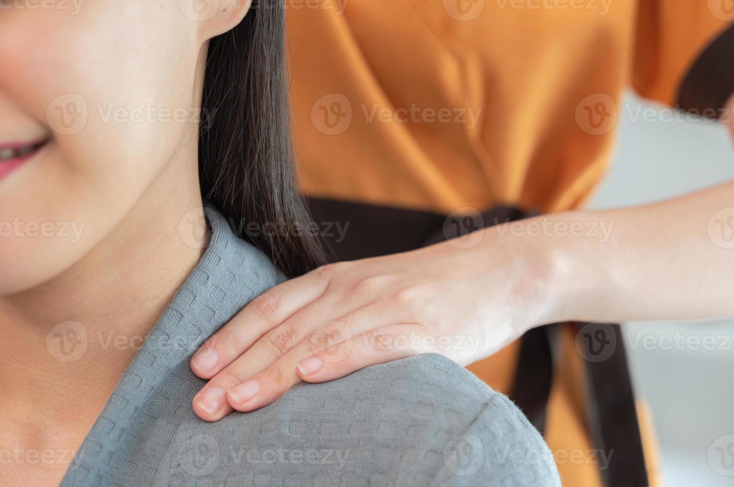 mãos de massagista fazem massagem no pescoço para mulher bonita na mesa de massagem foto