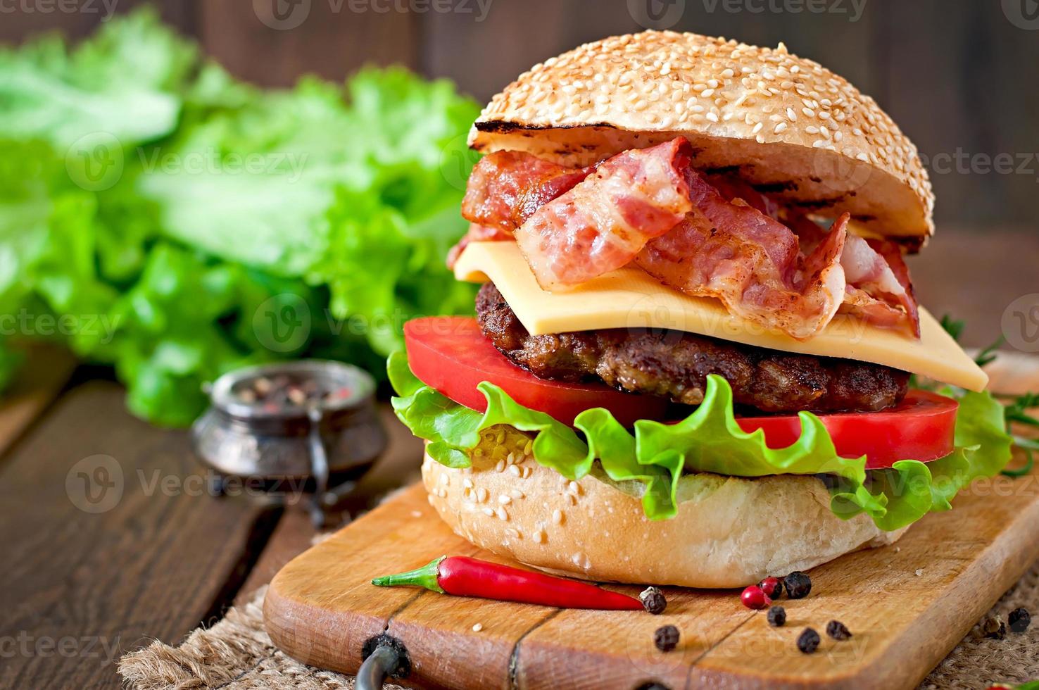 sanduíche grande - hambúrguer de hambúrguer com carne, queijo, tomate e bacon frito foto