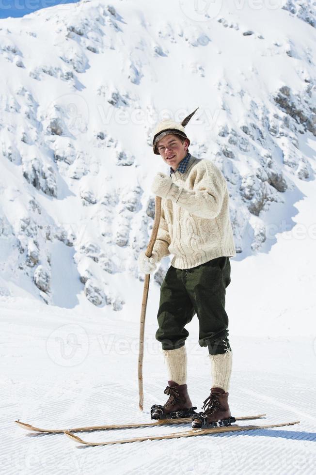 jovem esquiador vintage posando nas montanhas foto